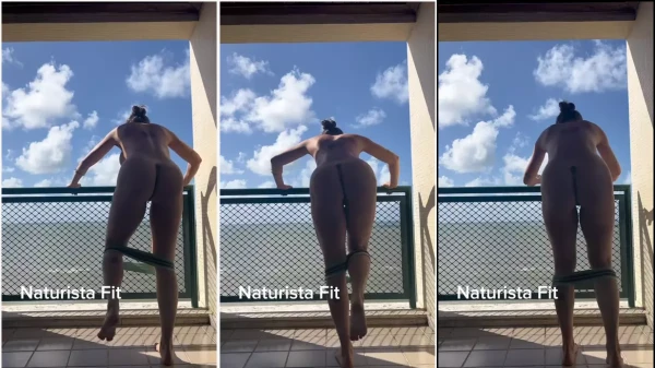 Naturist fit on the hotel balcony exercising